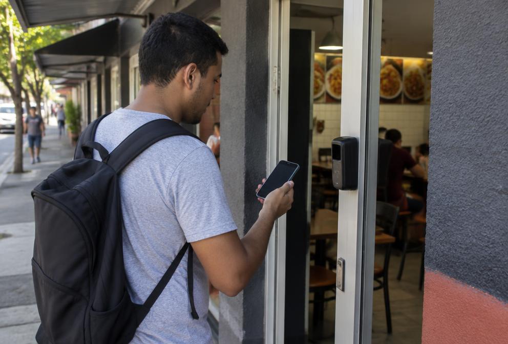 Garçom fazendo check-in por GPS na entrada do restaurante